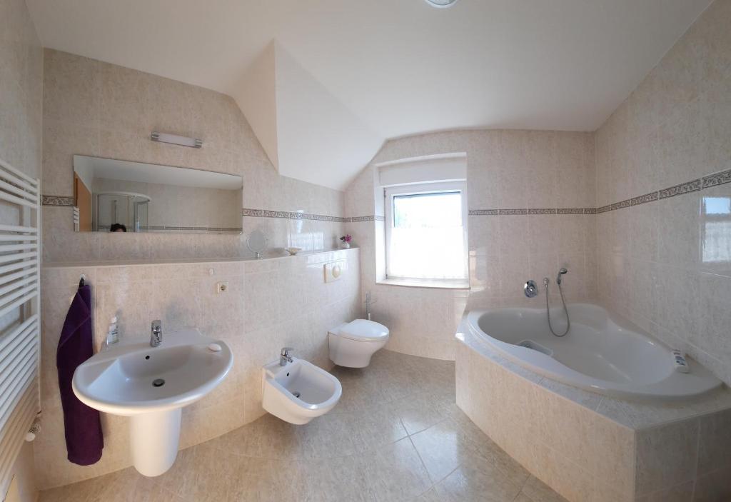 Neu SchloenにあるFerienwohnung Seeblickのバスルーム(シンク、バスタブ、トイレ付)