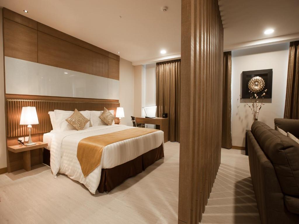 a hotel room with a bed and a couch at Garden Sentral Hotel in Kuala Belait