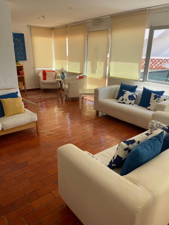 a living room with white couches and blue pillows at Pensão Dona Ana in Lagos