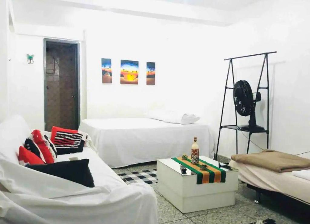 貝洛奧里藏特的住宿－Kitinet de fundos simples, completa - Em frente Materdei Contorno，白色的客房配有两张床和一张沙发