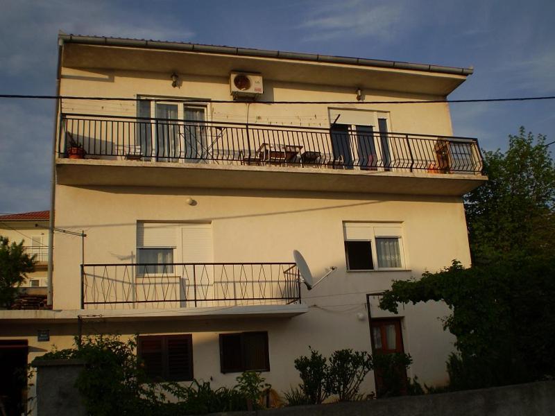 a building with a balcony with chairs on it at Apartman Seka in Senj