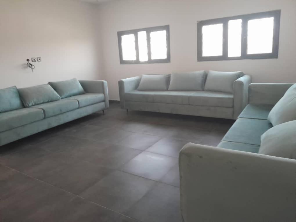 a living room with two couches and two windows at Suites & apartments Fderik in Nouadhibou