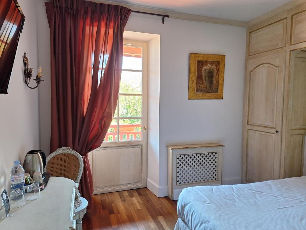 a bedroom with a bed and a window at Hotel Villa Catarie in Guéthary