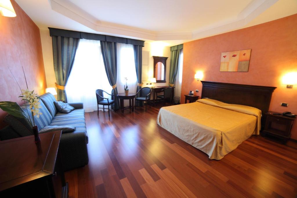pokój hotelowy z łóżkiem i kanapą w obiekcie Hotel Teocrito w Syrakuzach