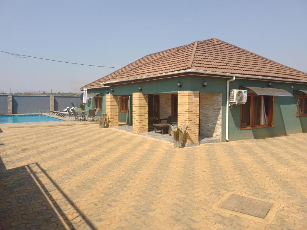 a house with a patio and a swimming pool at ALIJAY APARTMENTS in Mumbwa
