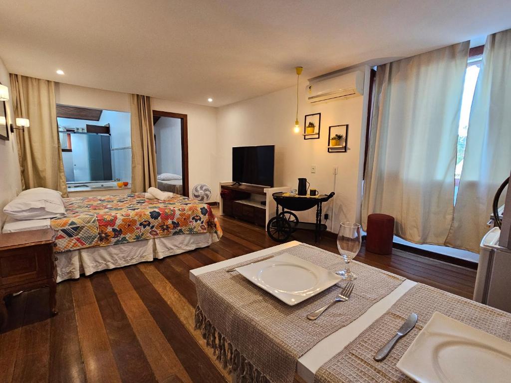 una camera d'albergo con due letti e una televisione di Studio com banheira de frente para o mar a Cabo Frio