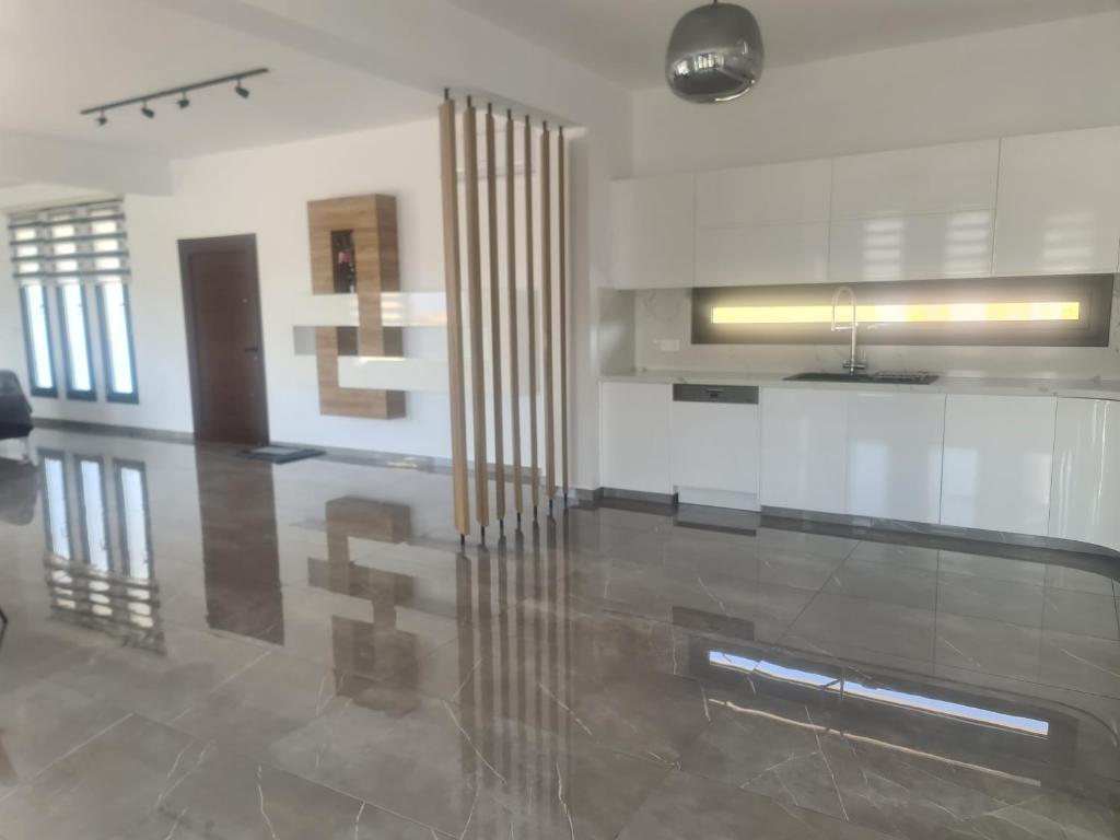 Eva Luxury Villa في لاشي: غرفة معيشة مع تقسيم زجاجي في غرفة