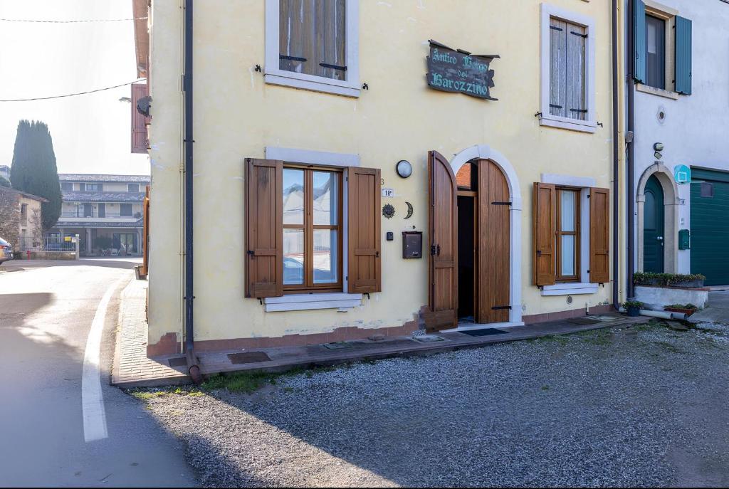 - un bâtiment avec des portes et des fenêtres en bois sur une rue dans l'établissement Casa Chiara a Valeggio sul Mincio, à Valeggio sul Mincio