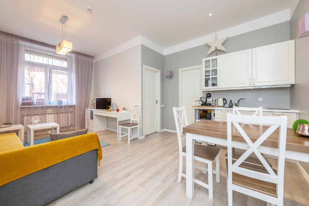 eine Küche und ein Wohnzimmer mit einem Tisch und Stühlen in der Unterkunft Main street apartments SELF CHECK IN 24/7 by H&H in Vilnius