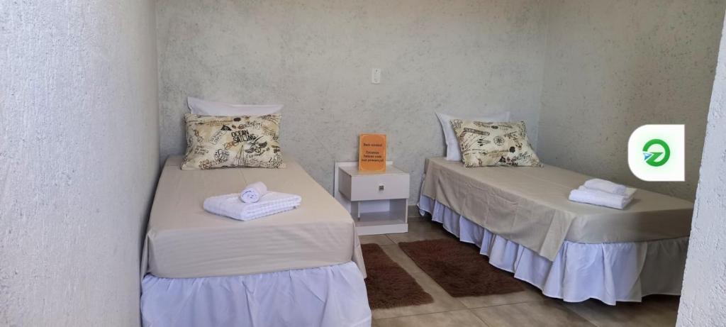 two beds in a room with a sign on the wall at Casa de 4 suites, perto do Thermas Water Park e Águas de são Pedro in São Pedro