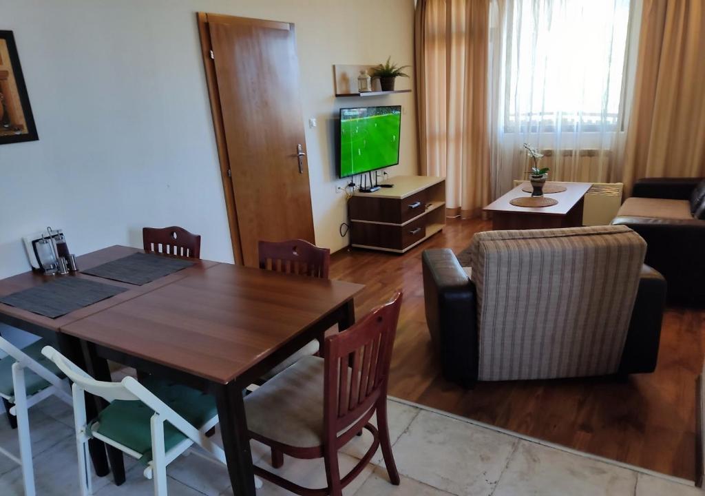 a living room with a dining room table and a television at Family 2 bed Apartment in Bansko in Bansko