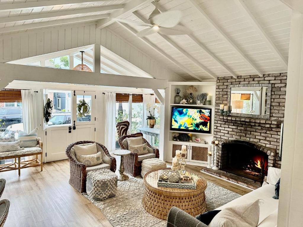 ein Wohnzimmer mit Kamin und Fernseher in der Unterkunft Balboa Island Beach Cottage in Newport Beach