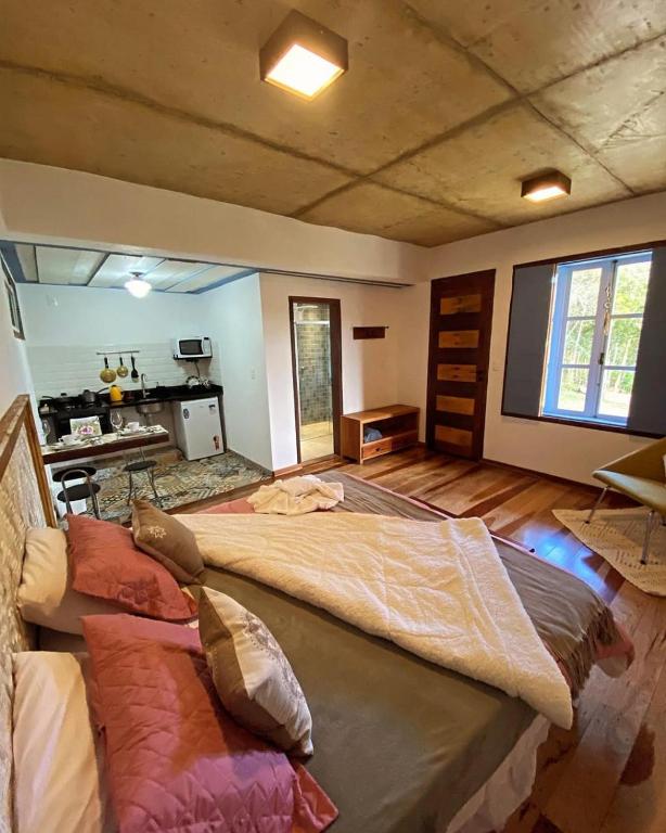 a large bedroom with a large bed in a room at Chalé Antúrios - Lavras Novas in Lavras Novas