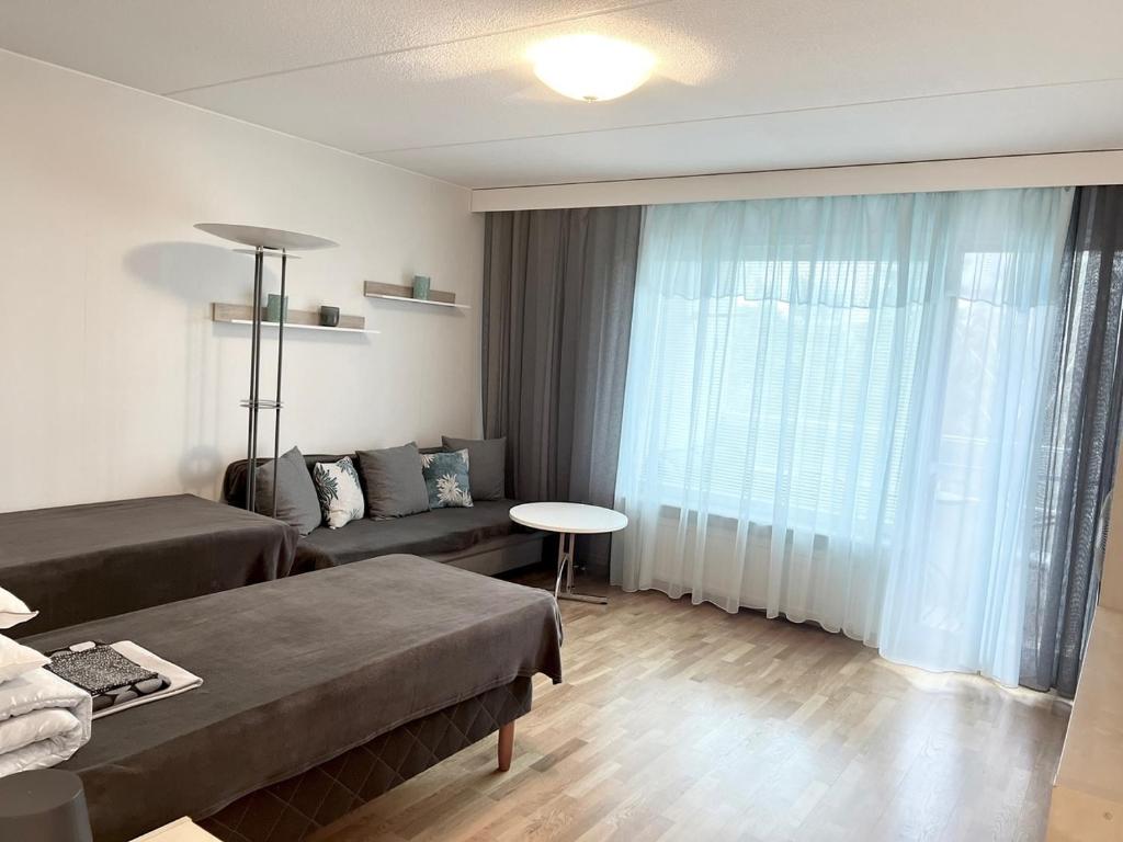 Habitación de hotel con cama, sofá y ventana en RANTA en Tampere