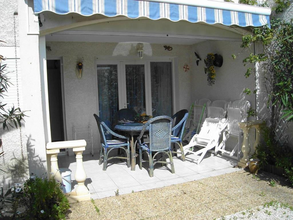 un patio avec une table et des chaises dessus dans l'établissement OREE DU GOLF II Agréable T3 traversant piscine côté golf Richelieu Cap d'Agde, au Cap d'Agde
