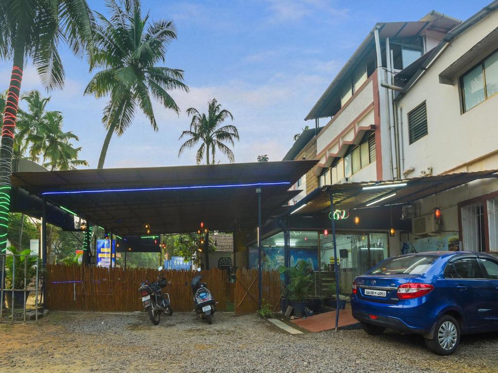 samochód zaparkowany przed budynkiem z motocyklem w obiekcie Collection O Goa Savera Holiday Homes w mieście Nerul