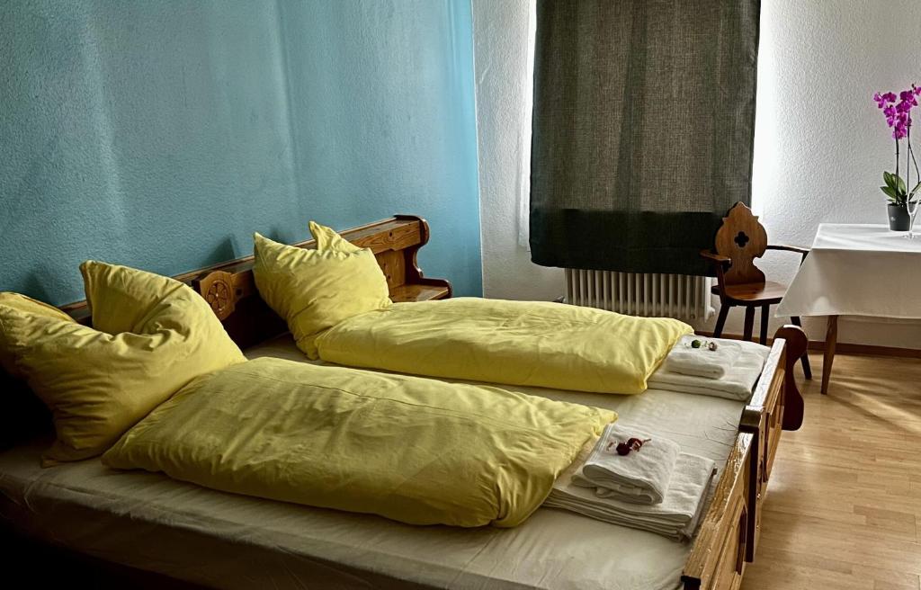 - 2 lits dans une chambre avec des draps jaunes dans l'établissement Gasthof Zur Post - Inning, à Inning am Ammersee