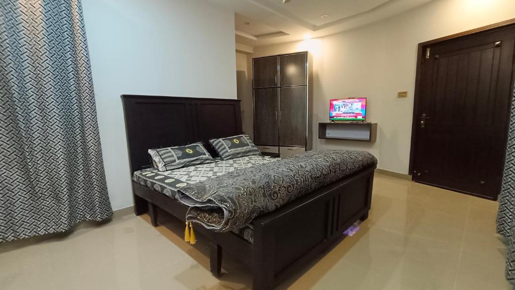 ein Schlafzimmer mit einem Bett und einem TV. in der Unterkunft GSS TOWER HOTEL in Lahore