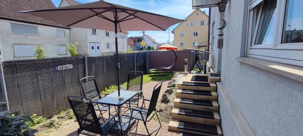 a patio with a table and chairs and an umbrella at Infinity Ferienwohnung/Home in Ostrach
