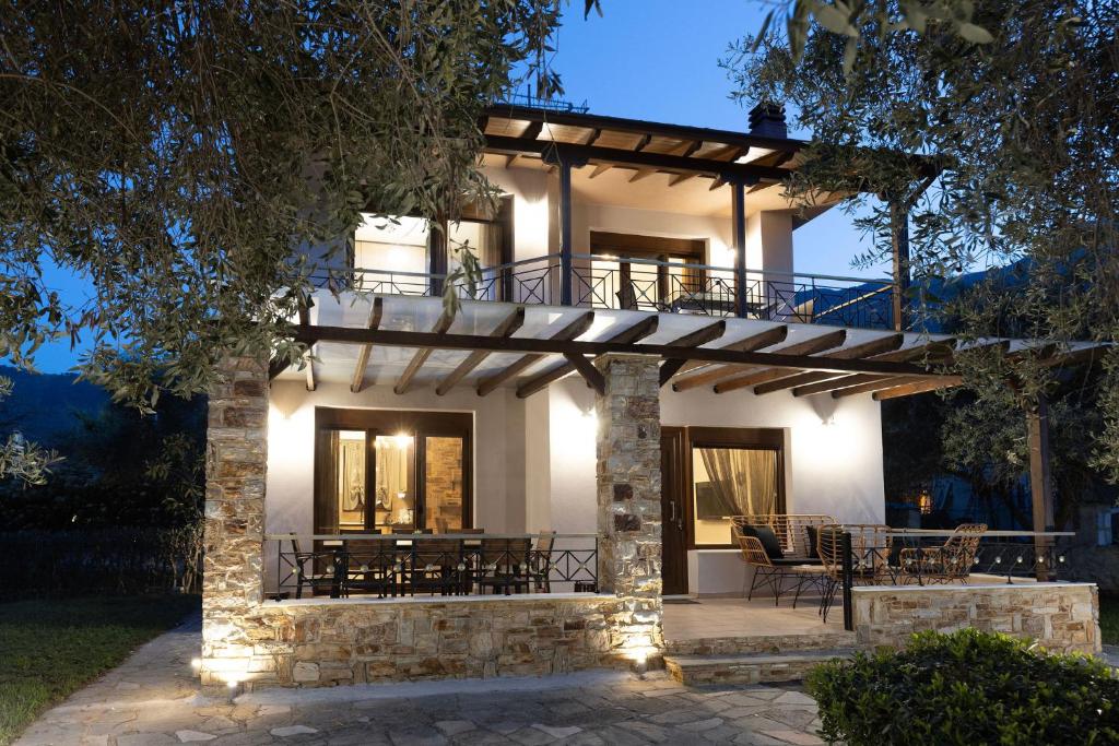 a house with a porch with tables and chairs at Villa Bellissimo in Skala Potamias