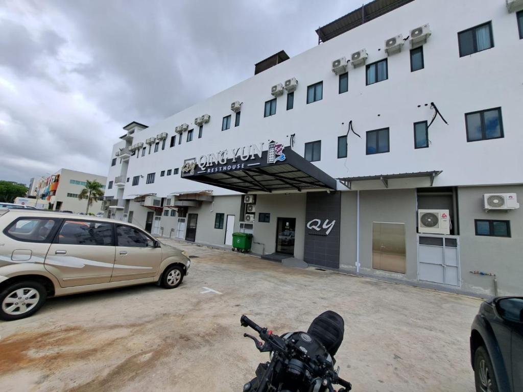 une voiture garée dans un parking en face d'un bâtiment dans l'établissement Qing Yun Rest House Koprijaya, Brunei Darussalam, à Bandar Seri Begawan