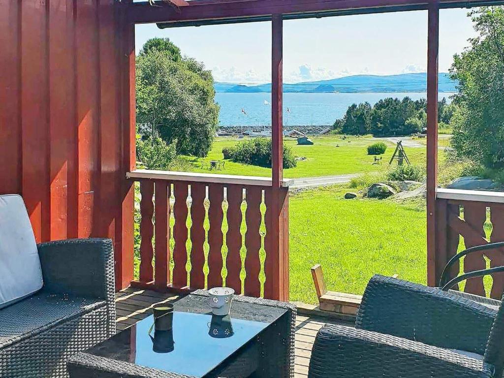a porch with a table and chairs and a large window at 6 person holiday home in Storfosna-By Traum in Sletta