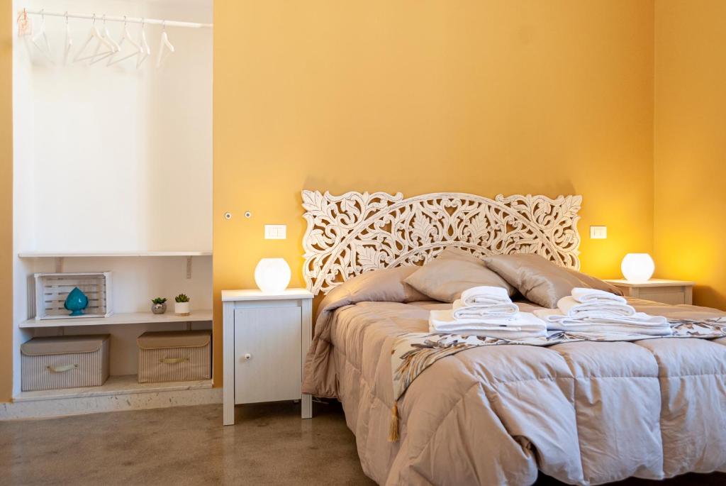 レッチェにあるLa Pigna Bianca Suitesのベッドルーム1室(黄色の壁のベッド1台、ランプ2つ付)