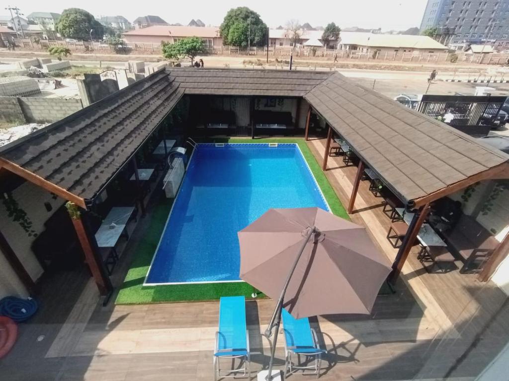 een uitzicht over een zwembad met een parasol bij MUNA SUITES in Owerri