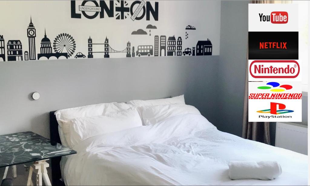 ein Schlafzimmer mit einem Bett mit weißer Bettwäsche und Städten an der Wand in der Unterkunft En-suite Soft Water Air Conditioning TV NEO in London