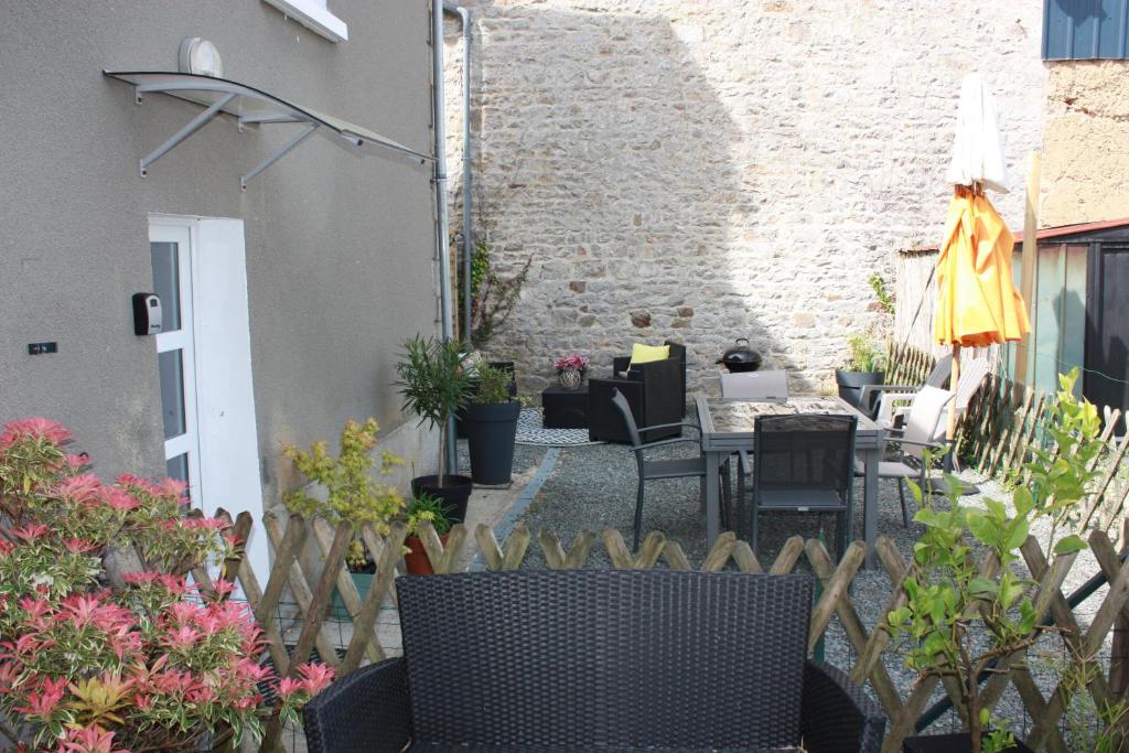 un patio extérieur avec des chaises, des tables et des fleurs dans l'établissement Charmant gite de Valérie et de Frédéric MAZA, à Quettreville-sur-Sienne
