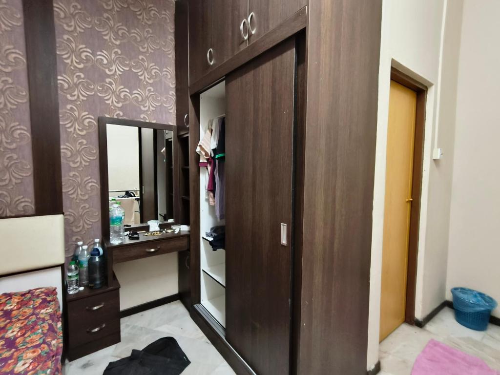 a bathroom with a wooden closet and a mirror at Pulai Homestay in Ipoh