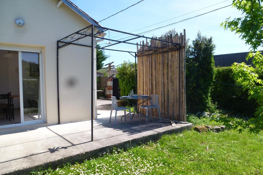 een patio met een tafel en stoelen in een tuin bij Maison Ustou46 in Cahors
