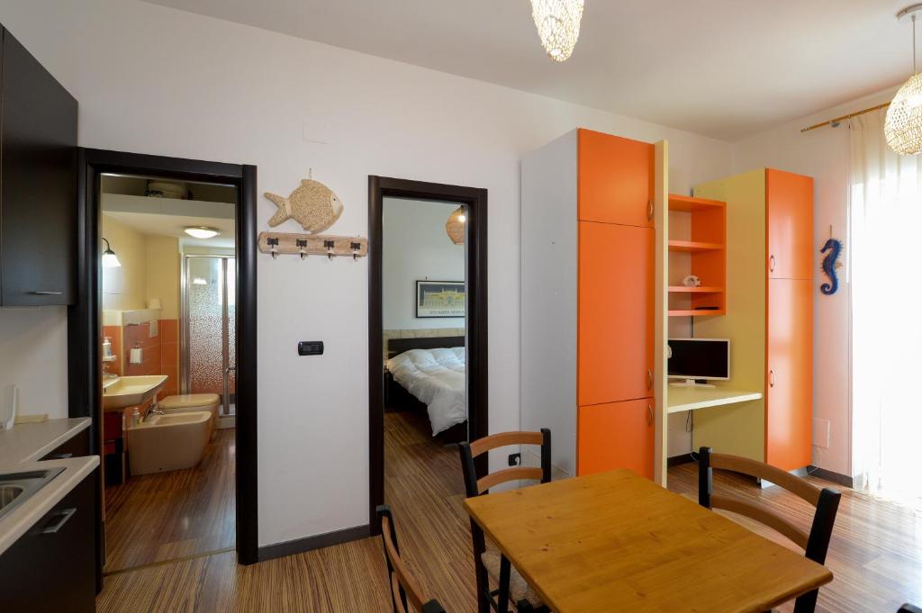 a kitchen and dining room with a table and a bedroom at Casa Lisanna - Cozy apartment by the Sea in Capitolo
