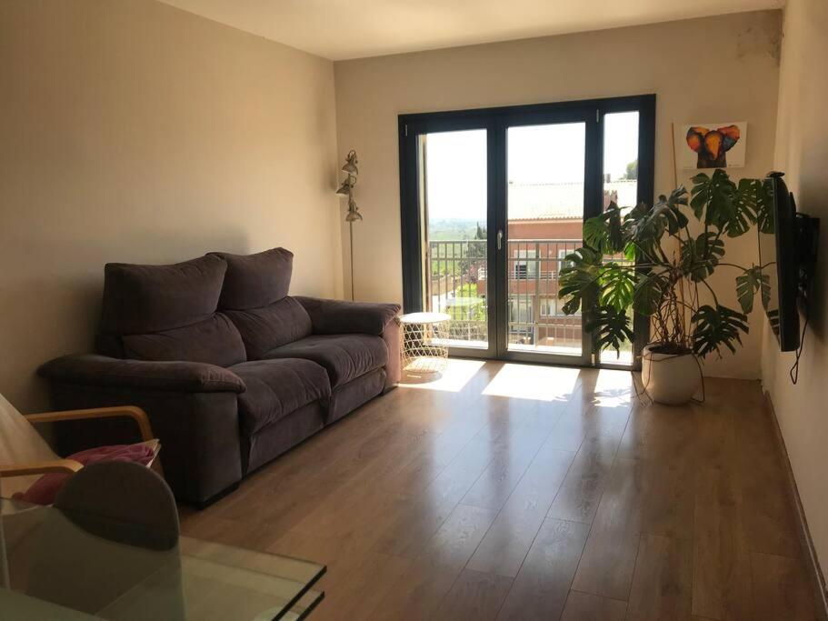 a living room with a couch and a sliding glass door at Piso en casa de pueblo in Almoster