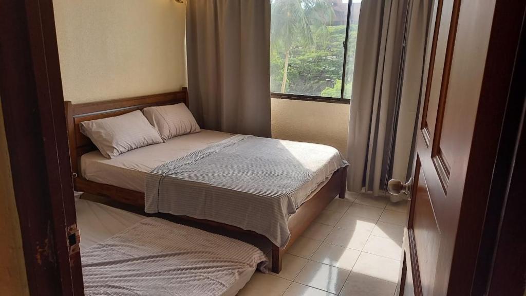 a small bedroom with two beds and a window at Seaput Srisayang in Batu Ferringhi