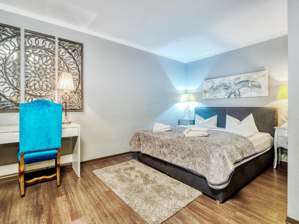Schlafzimmer mit einem Bett, einem Schreibtisch und einem Stuhl in der Unterkunft Central Hotel am Königshof in Viernheim