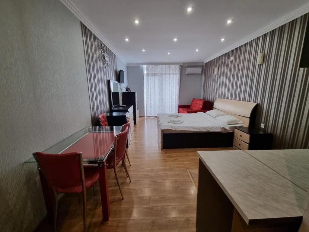 a hotel room with a bed and a table and chairs at Orbi Residence Volna,Batumi apart in Batumi