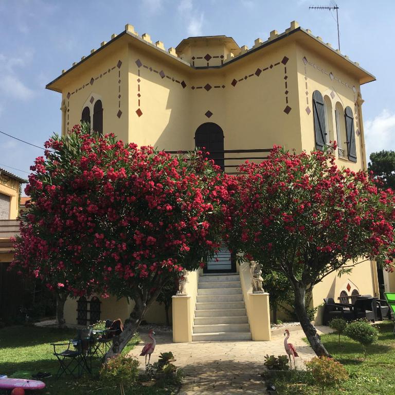 une église avec deux arbres et des fleurs roses dans l'établissement Les palmiers, à Nice