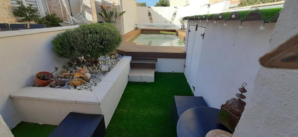 een kleine achtertuin met een zwembad en groen gras bij Chambre spacieuse, indépendante, 5mn de la gare in Narbonne