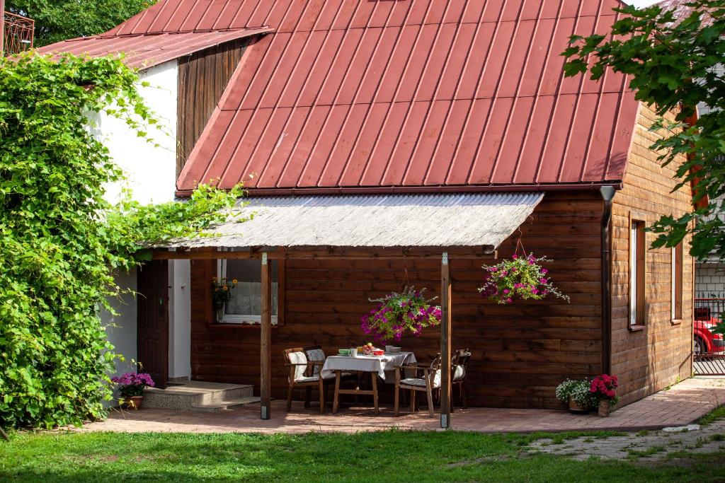 una casa con tetto rosso, tavolo e sedie di Domek Młodości a Augustów