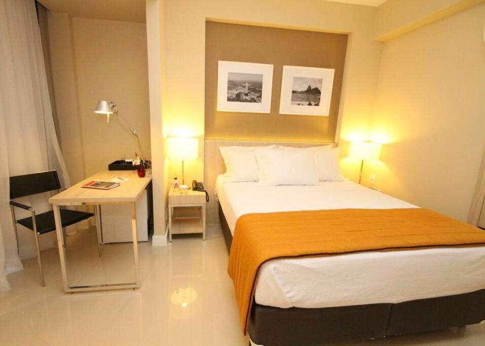 Suíte completa na Barra da Tijuca, Link Stay في ريو دي جانيرو: غرفة نوم بسرير ومكتب وسرير