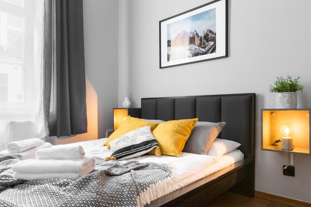 クラクフにあるFriendhouse Apartments Avenueのベッドルーム1室(黄色い枕のベッド1台付)