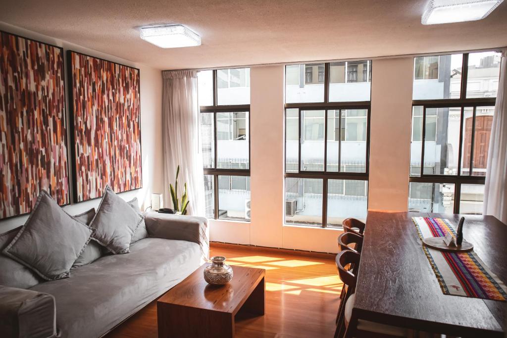 sala de estar con sofá, mesa y ventanas en HISTORIC CENTER PERUVIAN CLASIC Apartment, en Lima