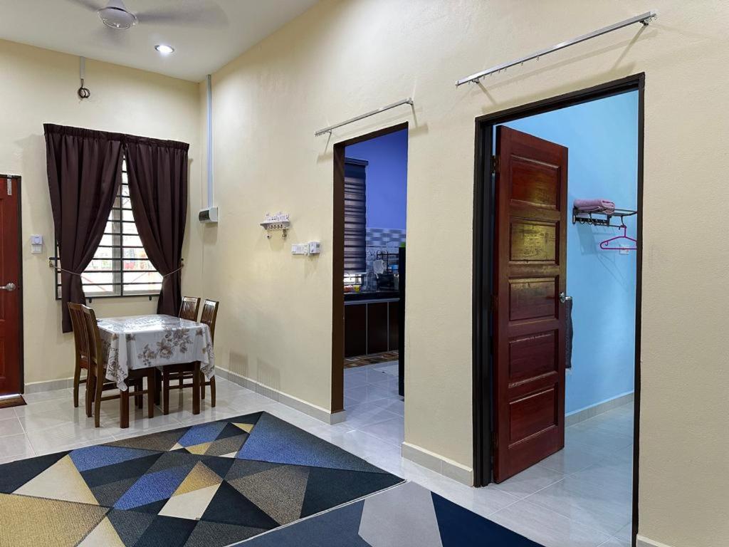 a room with a table and a dining room with a window at Homestay Haji Noor in Tanah Merah