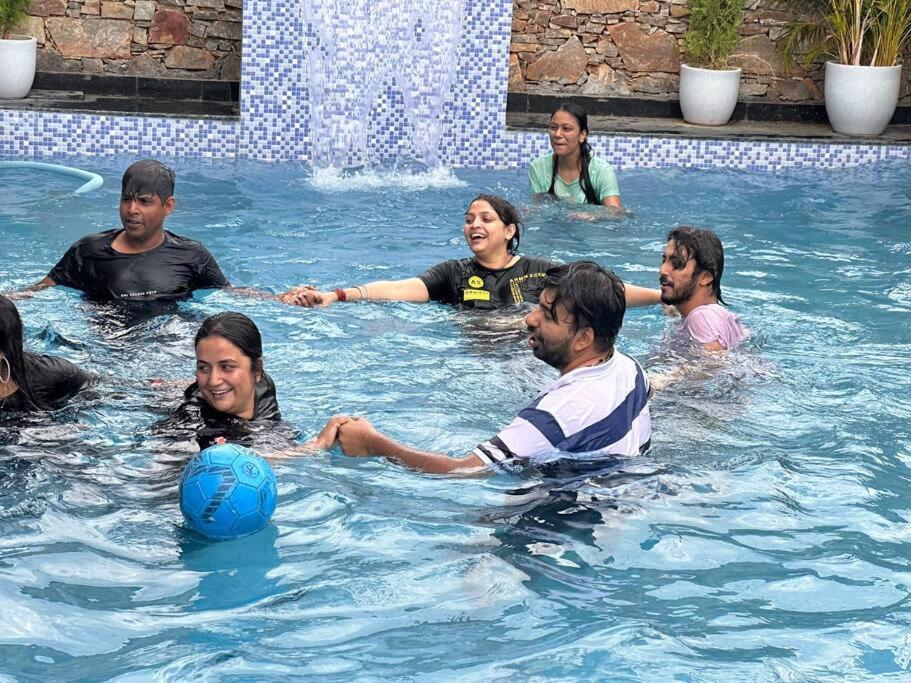 a group of people in a swimming pool at 2 bhk with private pool in Thūr