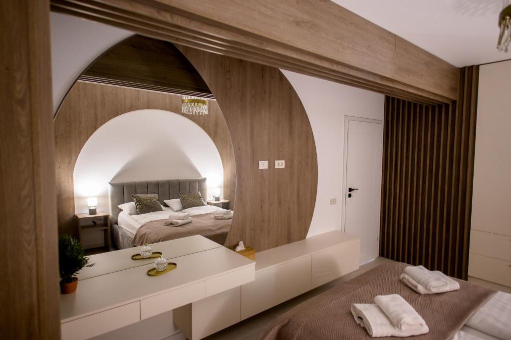 a bedroom with a bed and a large mirror at Prime Apartments City Centre 48 in Suceava