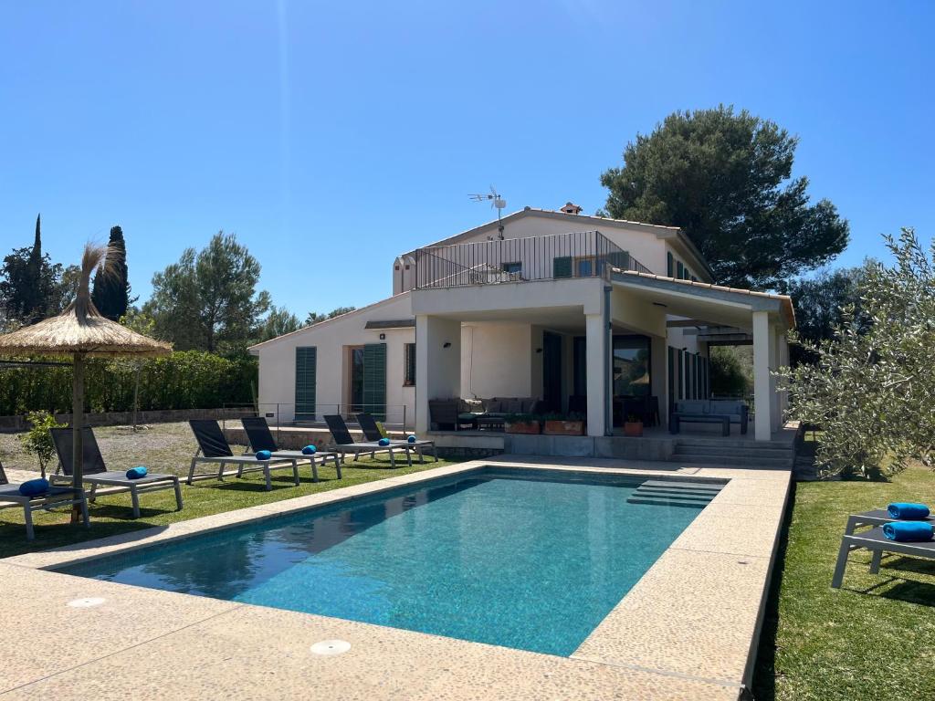 une villa avec une piscine en face d'une maison dans l'établissement Villa Olivar - La Goleta Hotel de Mar & Villas, à Pollença