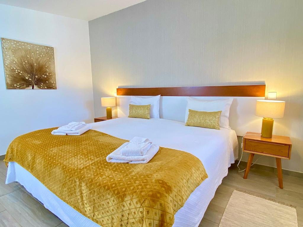 a bedroom with a large bed with towels on it at Quinta das Andorinhas in Carvoeiro