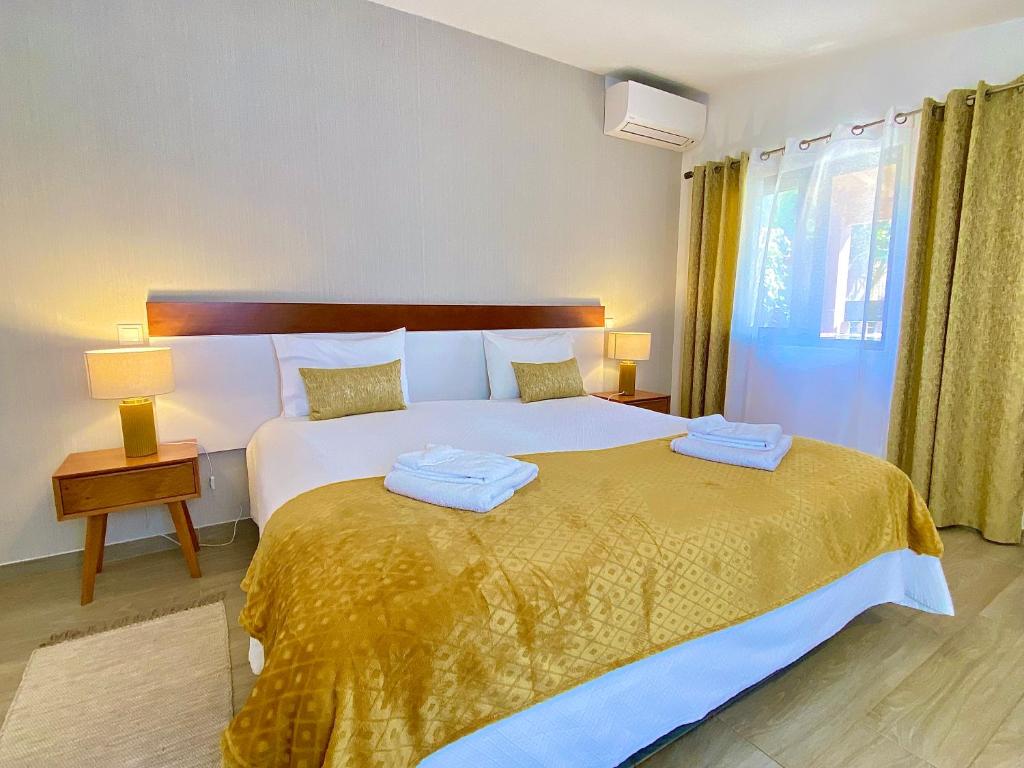 a bedroom with a large bed with two towels on it at Quinta das Andorinhas in Carvoeiro