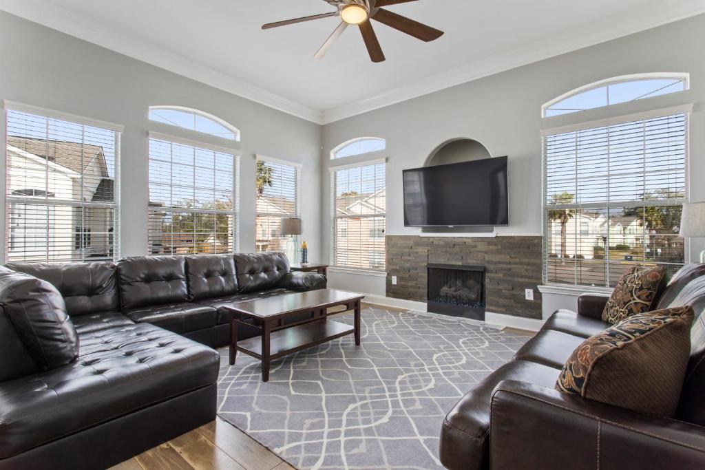 a living room with leather furniture and a fireplace at Luxury Condo in Gulfport in Gulfport